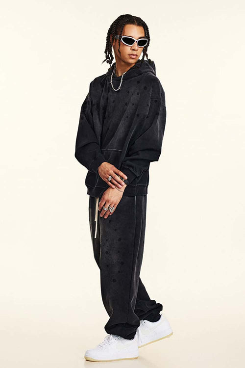 Washed Paint-Splatter Pullover Hoodie in Black - three-quarter front modeled view