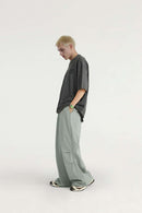 Layered-Pocket Drawstring Wide-Leg Pants in Grayish Green - full-length side modeled view
