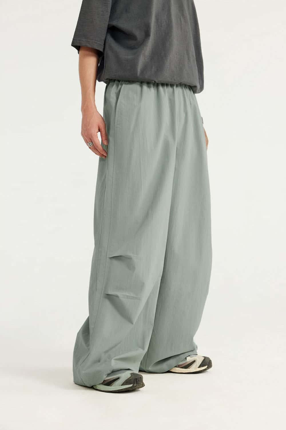 Layered-Pocket Drawstring Wide-Leg Pants in Grayish Green - three-quarter front modeled view