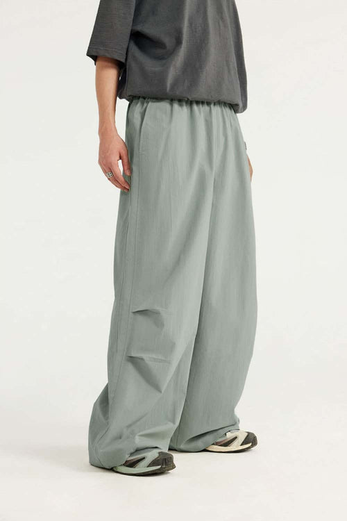 Layered-Pocket Drawstring Wide-Leg Pants in Grayish Green - three-quarter front modeled view