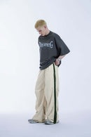 Striped Drawstring Loose Parachute Pants in Apricot - three-quarter front modeled view