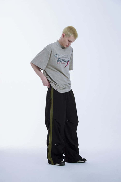 Striped Drawstring Loose Parachute Pants in Black - three-quarter front modeled view