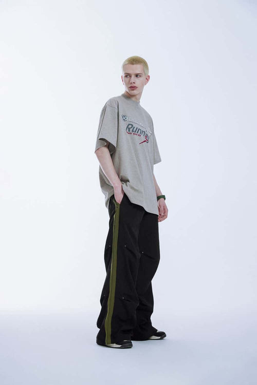 Striped Drawstring Loose Parachute Pants in Black - three-quarter front modeled view
