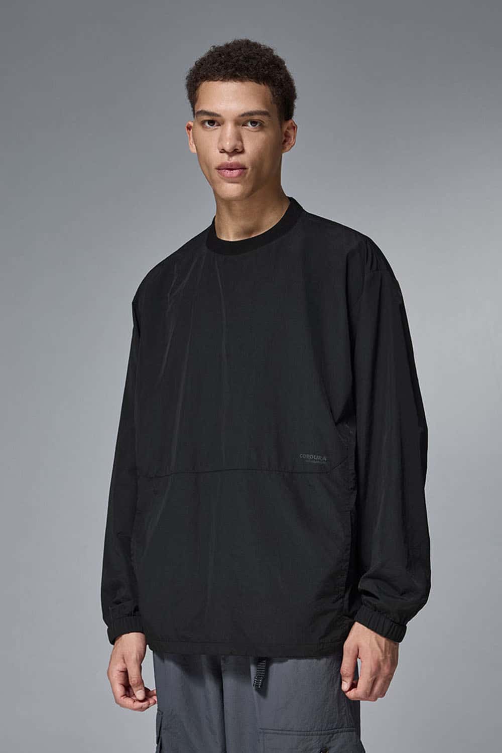 Utility Pocket Nylon Long-Sleeve Pullover in Black - front modeled close-up