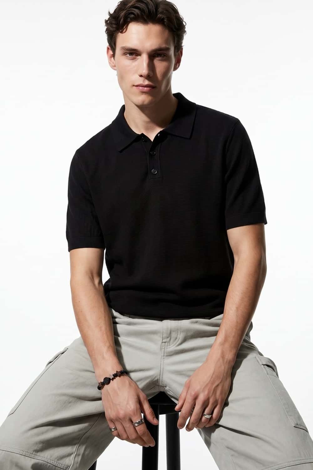 Relaxed Short-Sleeve Knit Polo Shirt in Black - full-length front modeled view