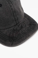 Six-Panel Cotton Baseball Cap with Cursive Artwork on the Brim in Vintage Black - product detail close-up