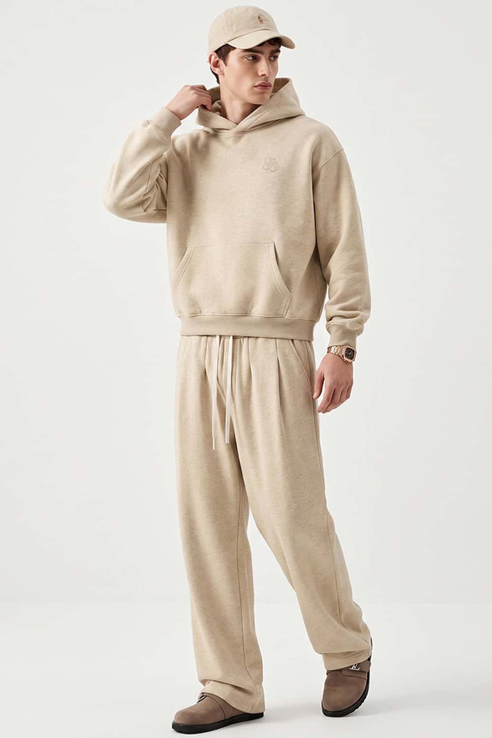 Relaxed Pullover Hoodie with Embroidered Emblem in Apricot - full-length front modeled view
