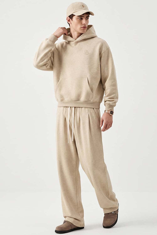 Relaxed Pullover Hoodie with Embroidered Emblem in Apricot - full-length front modeled view
