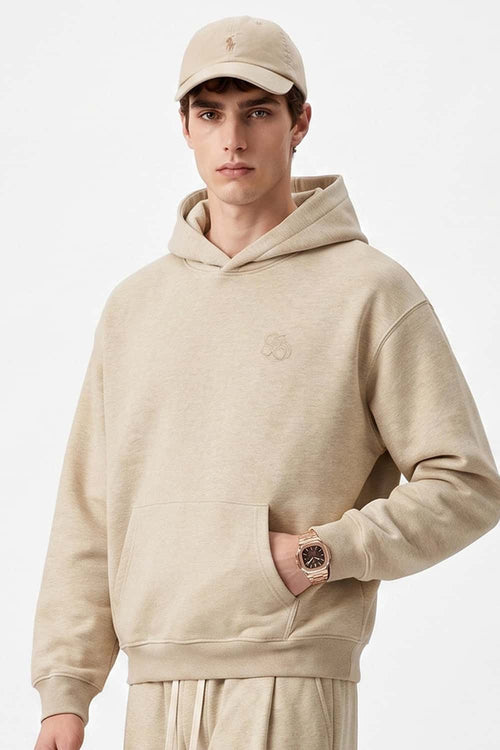 Relaxed Pullover Hoodie with Embroidered Emblem in Apricot - three-quarter front modeled view