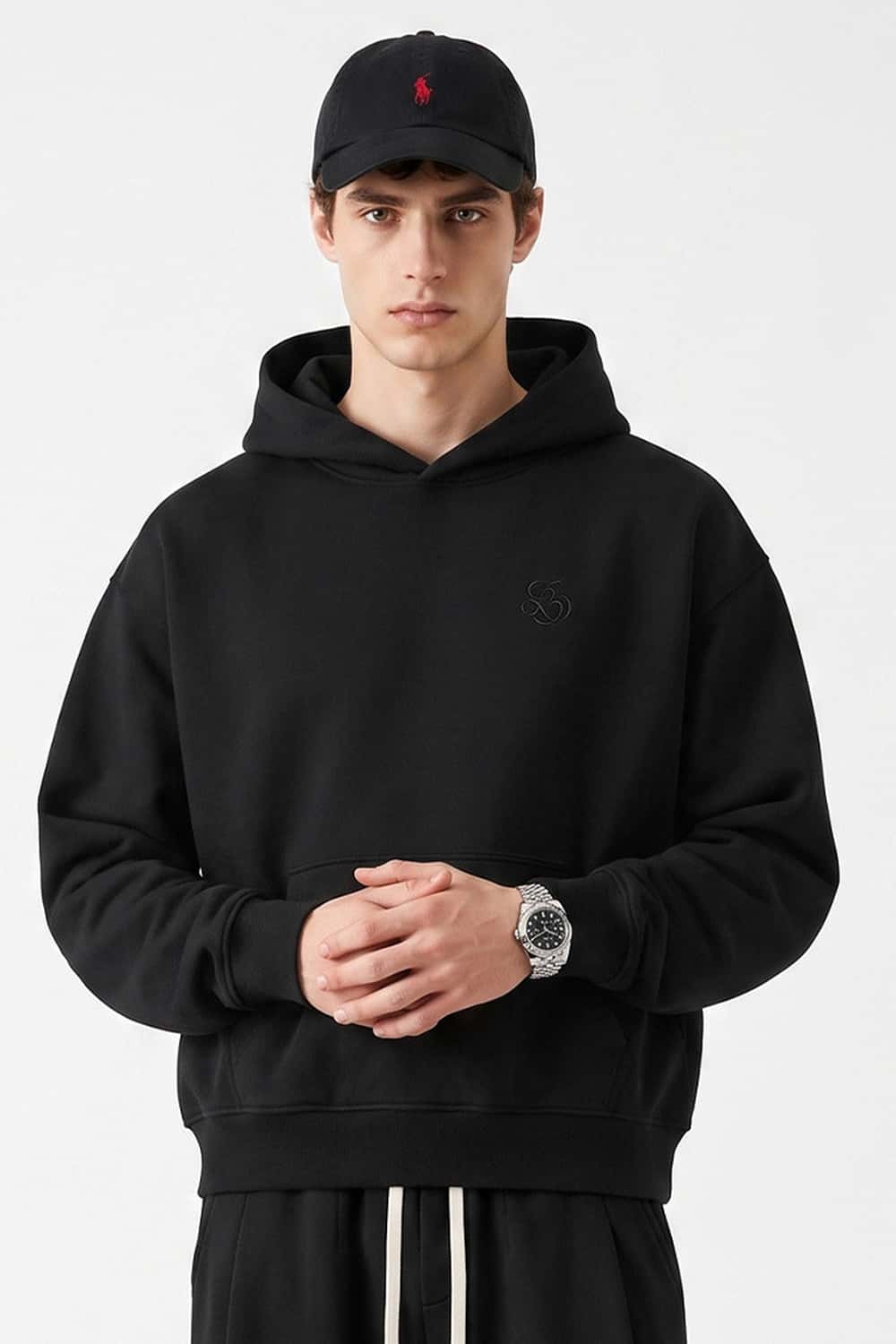 Relaxed Pullover Hoodie with Embroidered Emblem in Black - front modeled view