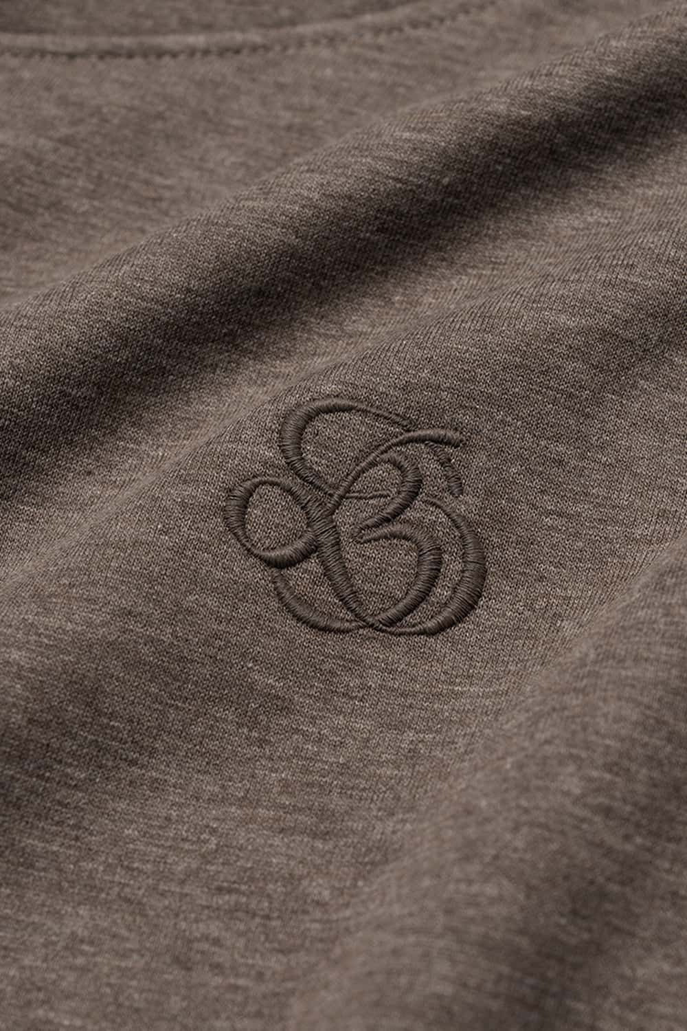 Relaxed Pullover Hoodie with Embroidered Emblem in Coffee - fabric texture close-up