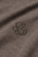 Relaxed Pullover Hoodie with Embroidered Emblem in Coffee - fabric texture close-up