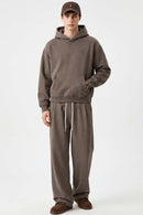 Relaxed Pullover Hoodie with Embroidered Emblem in Coffee - full-length front modeled view