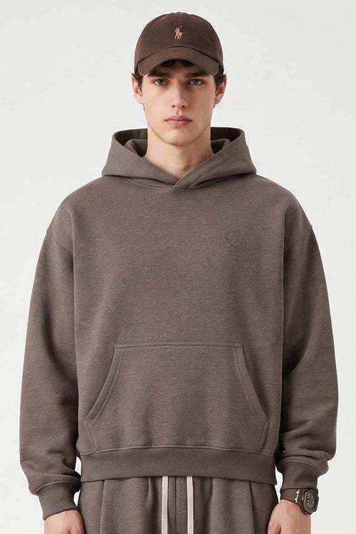 Relaxed Pullover Hoodie with Embroidered Emblem in Coffee - front modeled view
