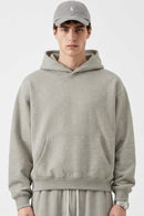 Relaxed Pullover Hoodie with Embroidered Emblem in Oat Gray - front modeled view