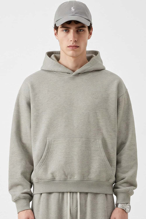 Relaxed Pullover Hoodie with Embroidered Emblem in Oat Gray - front modeled view